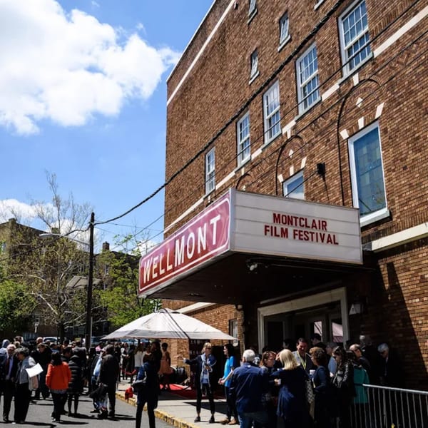 A crowd of people gathered outside the Wellmont Theater, displaying a "Montclair Film Festival" sign.