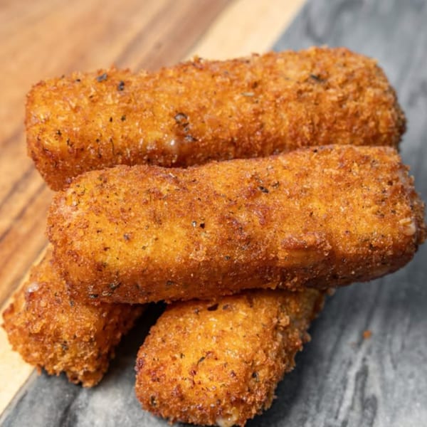 Three golden-brown, crispy mozzarella sticks from CARS Eatery, stacked on a dark surface.