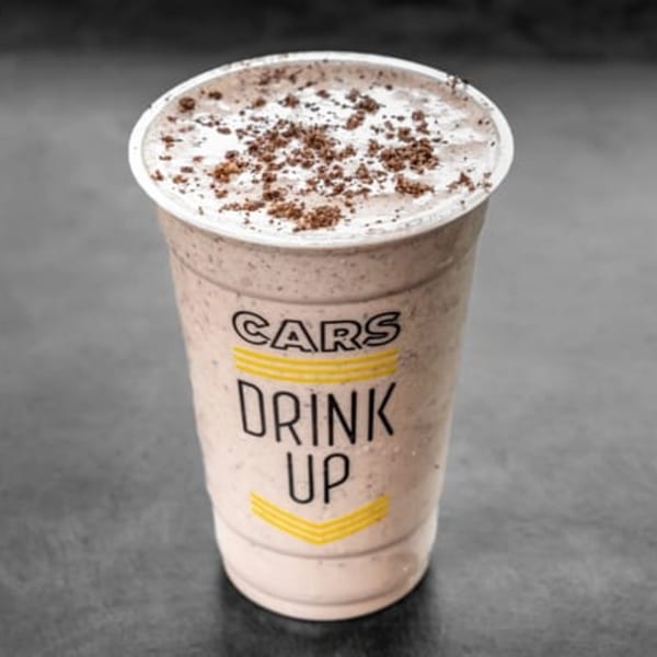 CARS Eatery's cookies and cream milkshake in a branded plastic cup with chocolate crumbles.